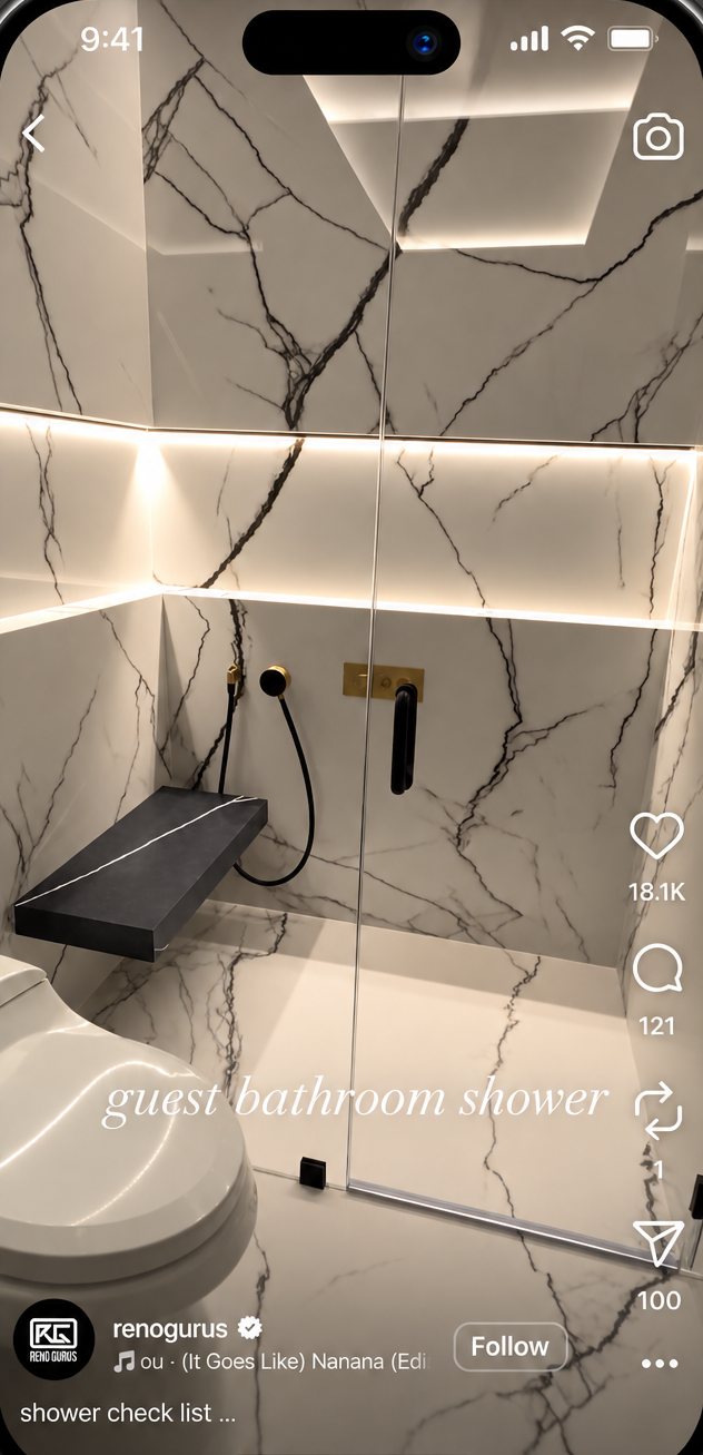 Marble walk-in shower with a floating bench, from a Reno Gurus Instagram reel.